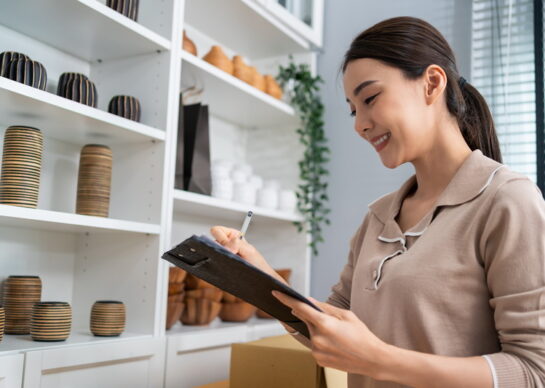 Asian beautiful woman check vase goods order for customer from shelf. Young attractive business girl working to preparing parcel boxes checking ecommerce shipping online retail to sell at home store.